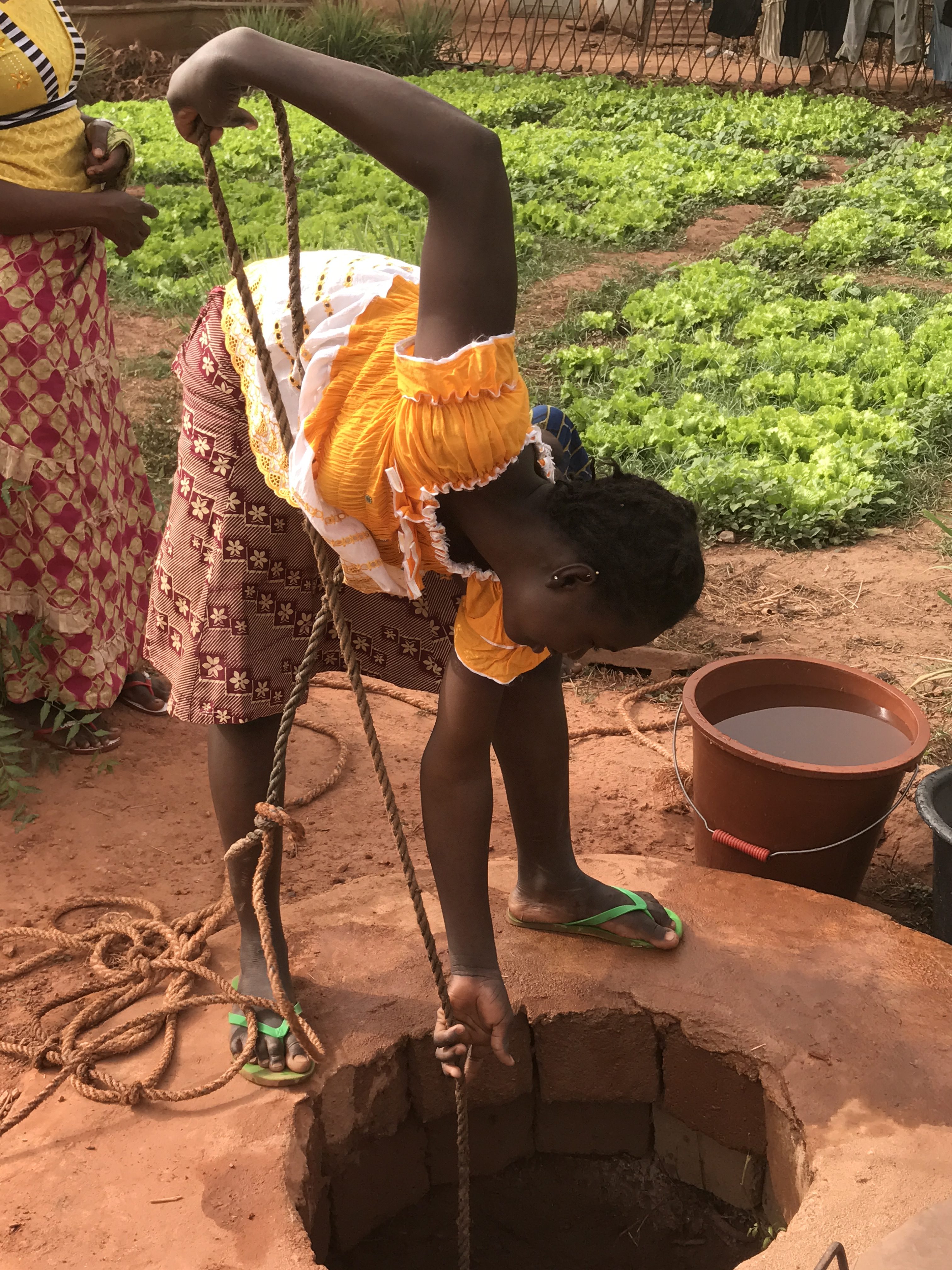 Jeune fille puisant de l'eau